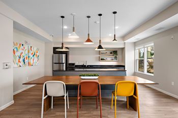 A kitchen with a table and chairs in front of it.